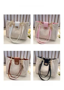 Detailed view of woven straw tote bags in off-white, pink, brown, and black colors