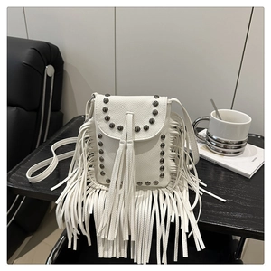 Macro detail of white pebble leather crossbody bag with fringes and metallic studs