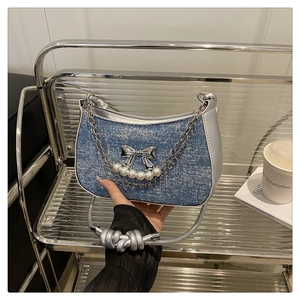Détail du sac en denim avec noeud papillon argenté et perles décoratives