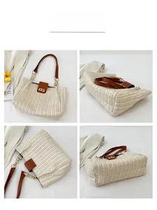 Detail view of woven straw tote bag with brown leather straps and gold metal hardware