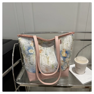 Detail of floral chiffon tote bag with pink leather base on a modern display shelf