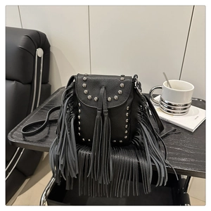 Close-up of vintage black crossbody bag with silver studs and long leather tassels