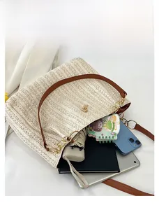 Top-down view of a cream straw tote bag showing large capacity for laptop and daily items
