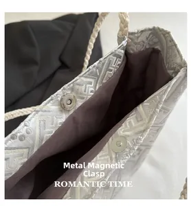 Close-up of magnetic silver metal closure on a woven tote bag with premium lining