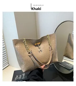 Detail of khaki tote bag featuring woven texture and reindeer metal pendant detail