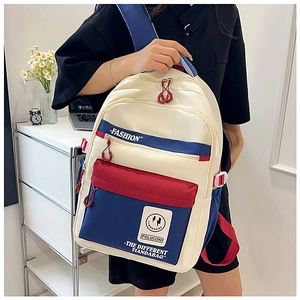 Detail of color-block canvas backpack showing multi-zipper pockets and durable nylon straps