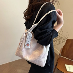 Pink floral canvas tote bag with woven shoulder strap and decorative silk scarf detail