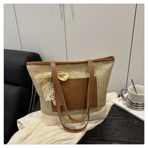 Close-up of woven straw tote bag with brown faux leather pocket and lace bow detail