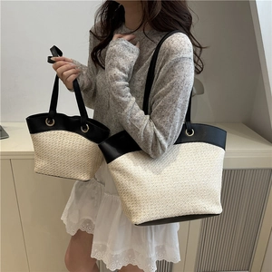 Large woven straw tote bag with black leather handles for summer beach and commute