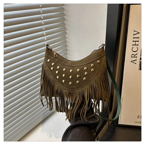 Detail of olive green suede handbag with gold rivets and long fringe tassels