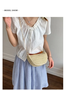 Detail of beige straw crossbody bag with amber beads and delicate gold chain strap