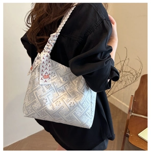 Detail of silver geometric jacquard tote bag with decorative printed silk scarf on strap