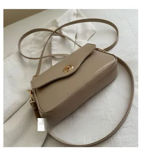 Détail du sac carré en cuir kaki montrant le fini texturé et le fermoir rotatif doré