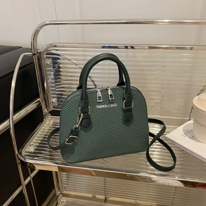 Modern dark green woven shell bag with silver hardware and adjustable leather strap