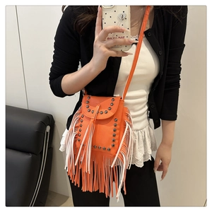 Detail of orange crossbody bag with litchi texture leather, metal studs and fringe