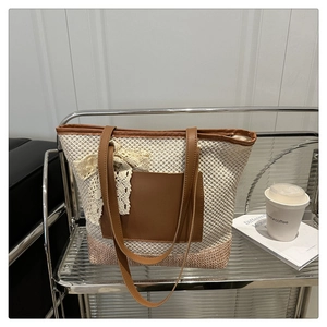 Close-up of woven tote bag with pink lace bow and brown leather front pocket detail