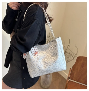 Detailed close-up of a silver ethnic tote bag with jacquard patterns and ribbon detail