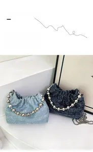Detail of denim bucket bags with chunky silver bead handles and metallic chain straps
