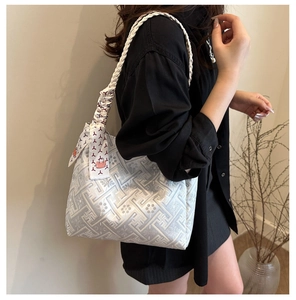 Detail of grey jacquard tote bag with woven shoulder strap and silk scarf accent