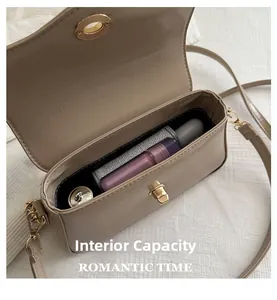 Vue détaillée du sac bandoulière beige montrant l'espace intérieur pour les objets
