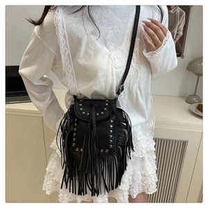 Detailed close-up of a black fringe crossbody bag with silver studs and long tassels