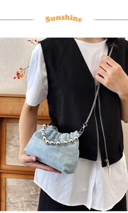 Detail of light blue denim cloud bag with silver bead handle and sparkling sequins