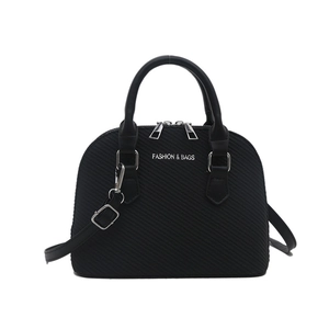 Minimalist black shell-shaped tote bag with twin handles and adjustable shoulder strap