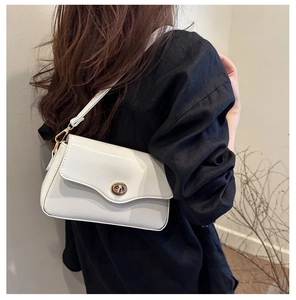 Détail du sac à bandoulière blanc carré avec rabat ondulé et fermoir doré tournant