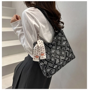 Detailed close-up of ethnic patterned jacquard tote bag with white silk scarf accessory