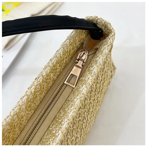 Détail du sac bandoulière en paille tisseé avec fermeture éclair dorée et anse en cuir