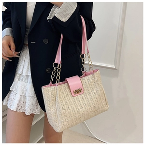 Close-up of pink leather trim and textured straw weaving on this elegant shoulder tote