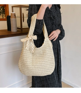 Detailed close-up of woven straw bag with lace bow decoration and texture detail