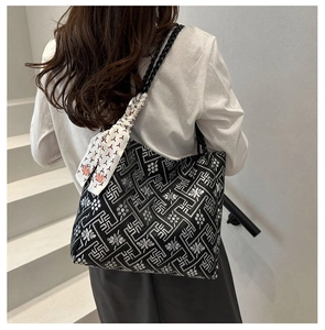 Detail of ethnic tote bag with geometric floral patterns and a decorative silk scarf