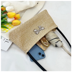 Détail d'un sac à main en paille tressée montrant l'intérieur pour accessoires