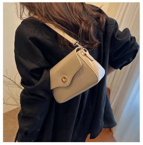 Petit sac carré beige élégant pour femme avec fermoir doré porté par un mannequin