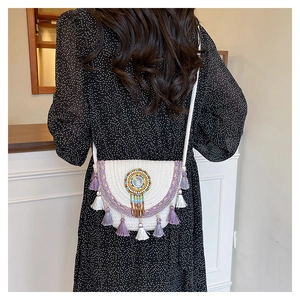 Close-up of white woven bag featuring ethnic purple embroidery and colorful beadwork