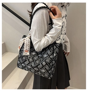 Detail of black ethnic tote bag with geometric patterns and decorative silk scarf