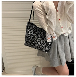 Ethnic style black tote bag with white geometric patterns and decorative silk scarf