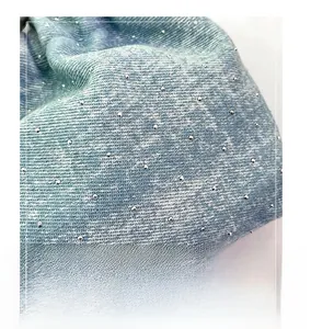 Detailed view of the gradient blue denim fabric with sparkling rhinestone embellishments