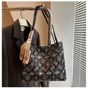 Detail of black ethnic tote bag with silver embroidery, woven handle and silk scarf decor