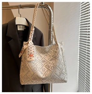 Detail of silver-grey jacquard tote bag with geometric patterns and decorative silk scarf