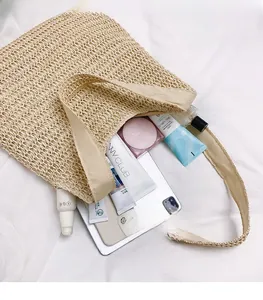 Detail showing the large capacity of a beige straw woven bag with essentials