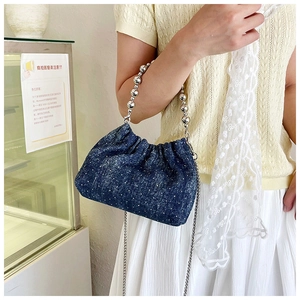 Detail of blue denim bucket bag with sparkling silver rhinestones and metal bead handle