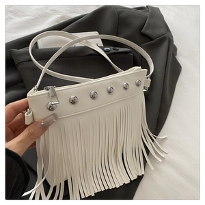 Dettaglio borsa a tracolla in ecopelle bianca con rivetti argento e lunghe nappe