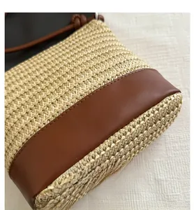 Détail du sac à bandoulière en paille tissé à la main avec coutures en cuir marron