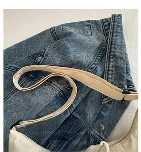 Close-up of beige canvas shoulder strap on minimalist tote bag with durable stitching