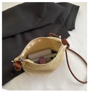 Détail de l'intérieur du sac bandoulière en paille montrant l'espace pour téléphone