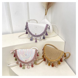Dettagli di borse a tracolla intrecciate boho con ricami etnici e nappe colorate