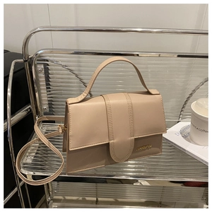 Détail du sac à rabat beige minimaliste avec logo JINGPIN sur un chariot élégant