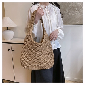 Fashionable large woven straw tote bag for beach vacations shown in a minimalist home setting